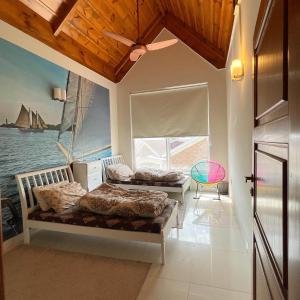 1 dormitorio con 2 camas y una ventana con un barco en Swiss Cottage Bhurban, en Bhurban