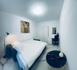 a white bedroom with a bed and a table at Golden Apartament in Şelimbăr +18 photos
