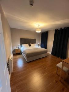 a bedroom with a bed and a wooden floor at Blacklion prime location apartment in Blacklion