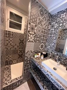 a bathroom with a sink and a mosaic wall at Appartement Cosy - Plein centre in Marseille