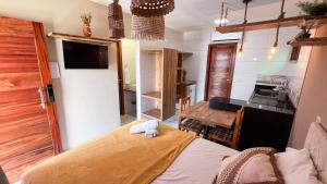 a small room with a bed and a kitchen at Volantes do Sertão - Ecoville in Piranhas