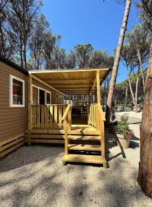 a cabin with a wooden porch with a roof at Camping Village Mare Pineta in Paestum