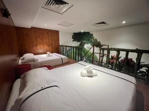 a hotel room with two beds and a balcony at Smile Hotel Shah Alam ICity in Shah Alam