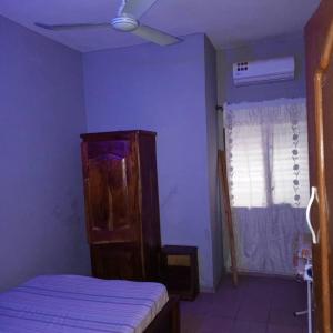 a bedroom with a bed and a ceiling fan at Appartement 2 Chambre Salon à Abomey-Calavi Bakita in Abomey-Calavi