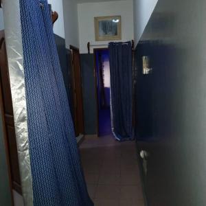 a hallway with blue curtains and a blue door at Appartement 2 Chambre Salon à Abomey-Calavi Bakita in Abomey-Calavi