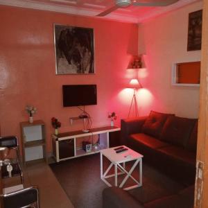 a red living room with a couch and a tv at Appartement 2 Chambre Salon à Abomey-Calavi Bakita in Abomey-Calavi