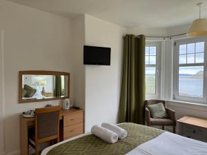 a hotel room with a bed and a desk and a mirror at Lochranza Country Inn in Lochranza