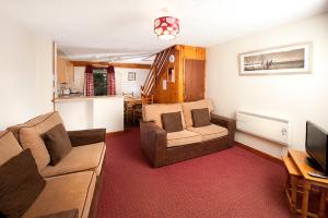 a living room with two couches and a television at Perran View Holiday Park in St. Agnes