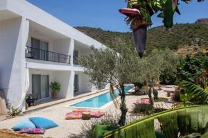 a villa with a swimming pool in front of a house at Gammi Hayıtbükü in Datca
