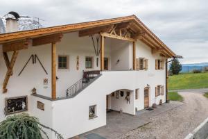Casa blanca grande con techo de madera en Ronsolhof Ortler en Siusi