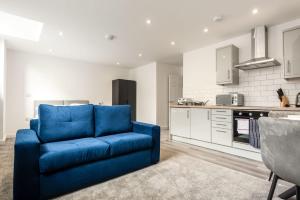 uma sala de estar com um sofá azul numa cozinha em Contemporary Studio Apartment in Central Rotherham em Rotherham