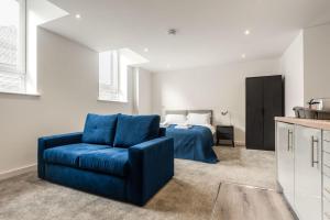 a living room with a blue couch and a bed at Contemporary Studio Apartment in Central Rotherham in Rotherham +6 photos