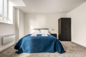 um quarto com uma cama com um cobertor azul em Contemporary Studio Apartment in Central Rotherham em Rotherham