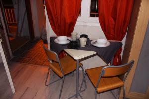 uma pequena mesa e cadeiras num quarto com cortinas vermelhas em Amazing Studio Next To Center 10 minutes walk no1 em Tessalônica