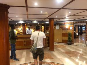Dwóch mężczyzn stojących w barze w holu hotelowym w obiekcie Five Star Nile Cruise from Aswan to Luxor w mieście Aswan