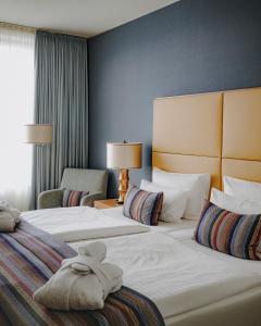 a hotel room with two beds and a window at AMERON Köln Hotel Regent in Cologne