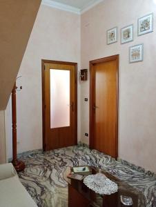 Zimmer mit einem Bett und einer Holztür in der Unterkunft Regina di denari in Pachino