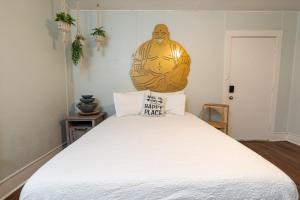 a bedroom with a white bed with a large statue on the wall at Depot Village in Gainesville