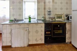 cocina con fogones negros y fregadero en Casa de Mila en Creciente Pontevedra, en Crecíente