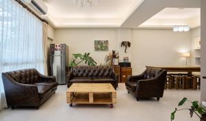 a living room with two leather couches and a coffee table at 像個家plus民宿 AT home plus B&B in Hualien City