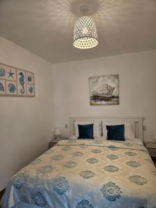 a bedroom with a bed with a blue and white comforter at Casa EMMA in Jurilovca