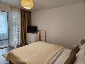 a bedroom with a bed and a flat screen tv at Casa EMMA in Jurilovca