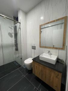 a bathroom with a sink and a toilet and a mirror at Penthouse Living in Mombasa