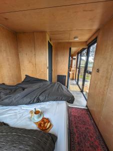 ein Bett in einem winzigen Haus mit einem Tablett mit Essen drauf in der Unterkunft The Coppleridge Inn, Eco-friendly cabins in the Dorset countryside with heating and hot water in Shaftesbury