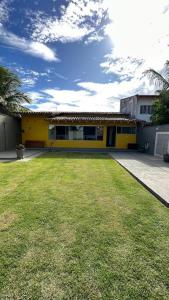ein gelbes Haus mit Rasen davor in der Unterkunft Casa Amarela in Serra