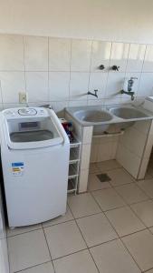a small bathroom with a sink and a washing machine at Casa Amarela in Serra +33 photos