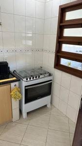 - une cuisine avec une cuisinière dans l'établissement Casa Amarela, à Serra