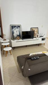 - un salon avec une télévision et un canapé dans l'établissement Casa Amarela, à Serra