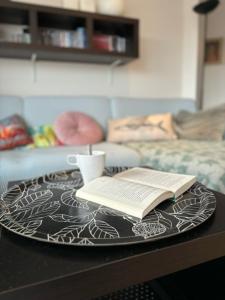 uma mesa com um prato com um livro e um copo em Walter Vilain 0503 - 5 min De La Plage em Koksijde