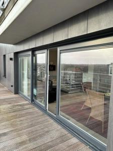 un porche con puertas correderas de cristal en una casa en Walter Vilain 0503 - 5 min De La Plage, en Koksijde