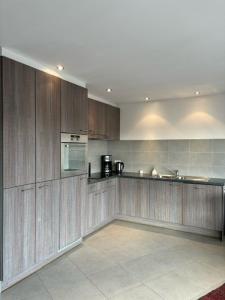 uma grande cozinha com armários e electrodomésticos de madeira em Walter Vilain 0503 - 5 min De La Plage em Koksijde
