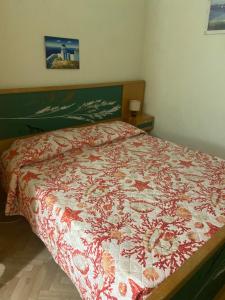 una camera con un letto e un piumone rosso e bianco di Appartamento Bouganville: CITRA: 011017-LT-0910 a Levanto