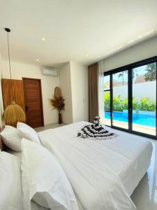 DalungにあるCosy 2bed/2bath villa 5 min to beachのベッドルーム(大きな白いベッド1台、プール付)