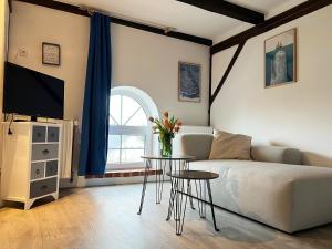 a living room with a couch and a table with flowers at Ferienhof Landlord in Fehmarn