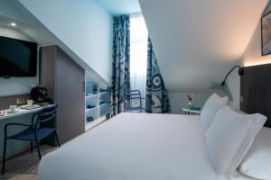 um quarto com uma grande cama branca e uma secretária em Best Western Alba em Nice