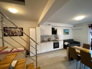 a living room with a kitchen and a dining room at Apartmani Spaija in Kaštela