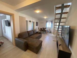 a living room with a couch and a spiral staircase at Apartmani Spaija in Kaštela