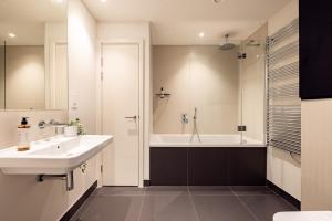 a bathroom with a sink and a bath tub at London Croydon by Charles Hope in Croydon