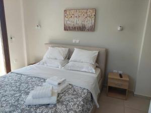 a bedroom with a bed with towels on it at Κamares View (Αύρα) in Ayeranós