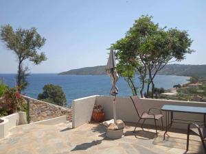 een patio met een parasol en een tafel en stoel bij Κamares View (Αύρα) in Ayeranós
