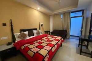 a bedroom with a bed with a red blanket at Goroomgo Garden Reach Boutique Stay Mall Road Mussoorie - A Luxury Room Stay in Mussoorie