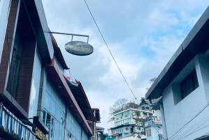 un panneau suspendu au-dessus d'une rue avec des bâtiments dans l'établissement Goroomgo Garden Reach Boutique Stay Mall Road Mussoorie - A Luxury Room Stay, à Mussoorie