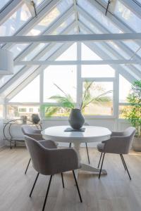 mesa y sillas en una habitación con techo blanco en GuestReady - Modernised cottage in Monkstown en Dublín