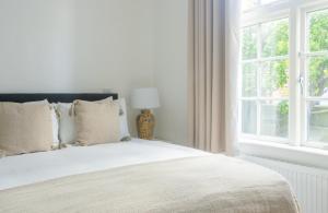 een slaapkamer met een wit bed en een raam bij GuestReady - Modernised cottage in Monkstown in Dublin