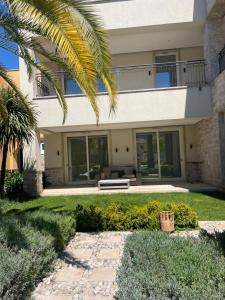 dom z ławką na podwórku w obiekcie Portonovi Lux apartman w mieście Ðenovići