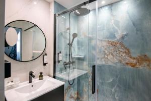 uma casa de banho com um chuveiro, um lavatório e um espelho. em Best Western Alba em Nice